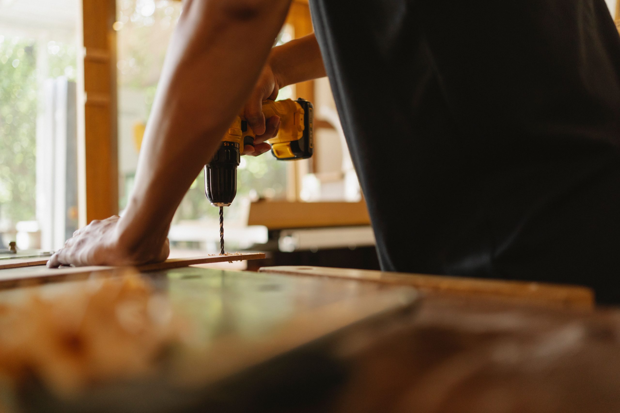 Artisan perçant une planche de bois