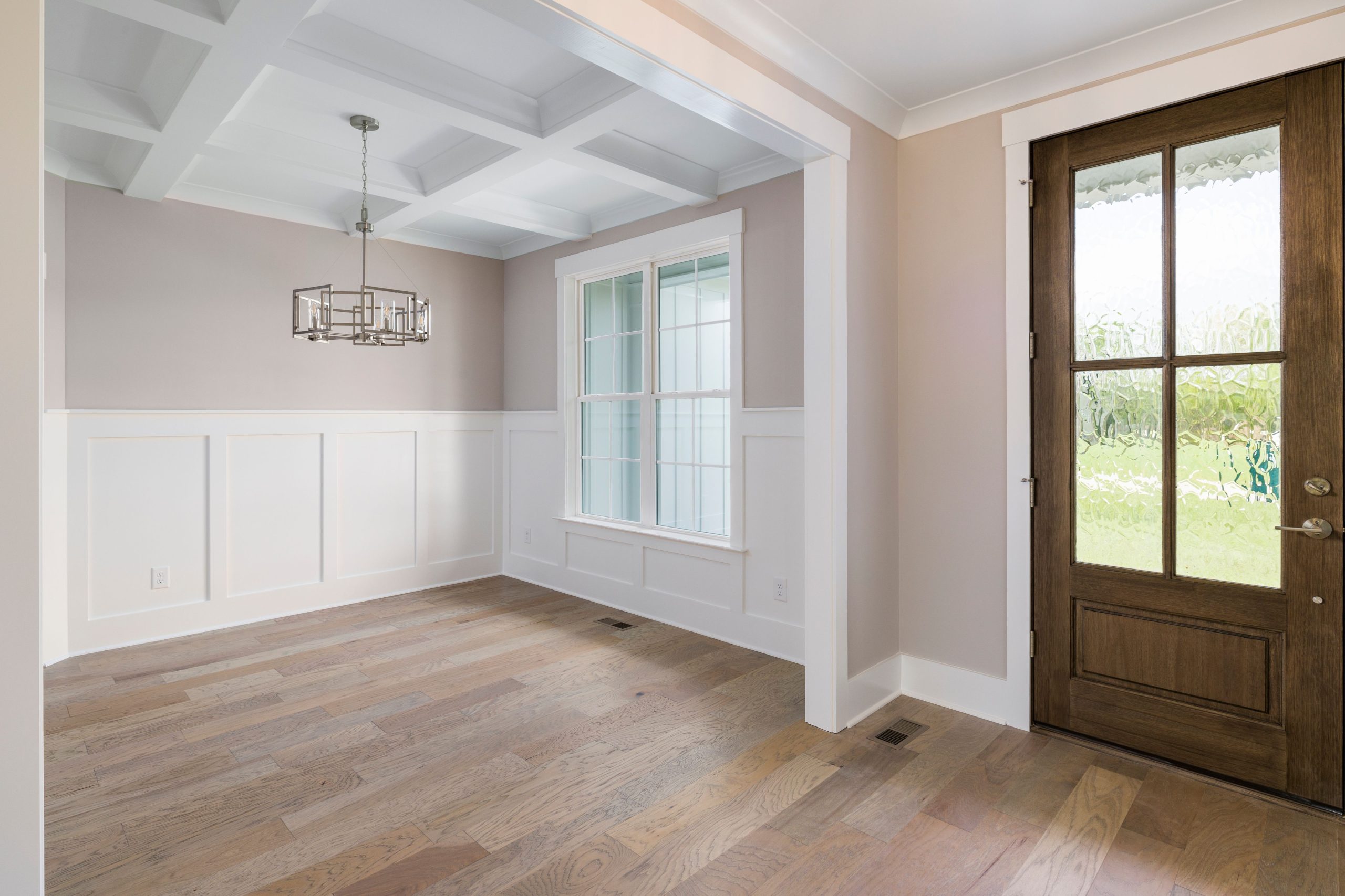 Porte en bois et parquet sous un lustre élégant